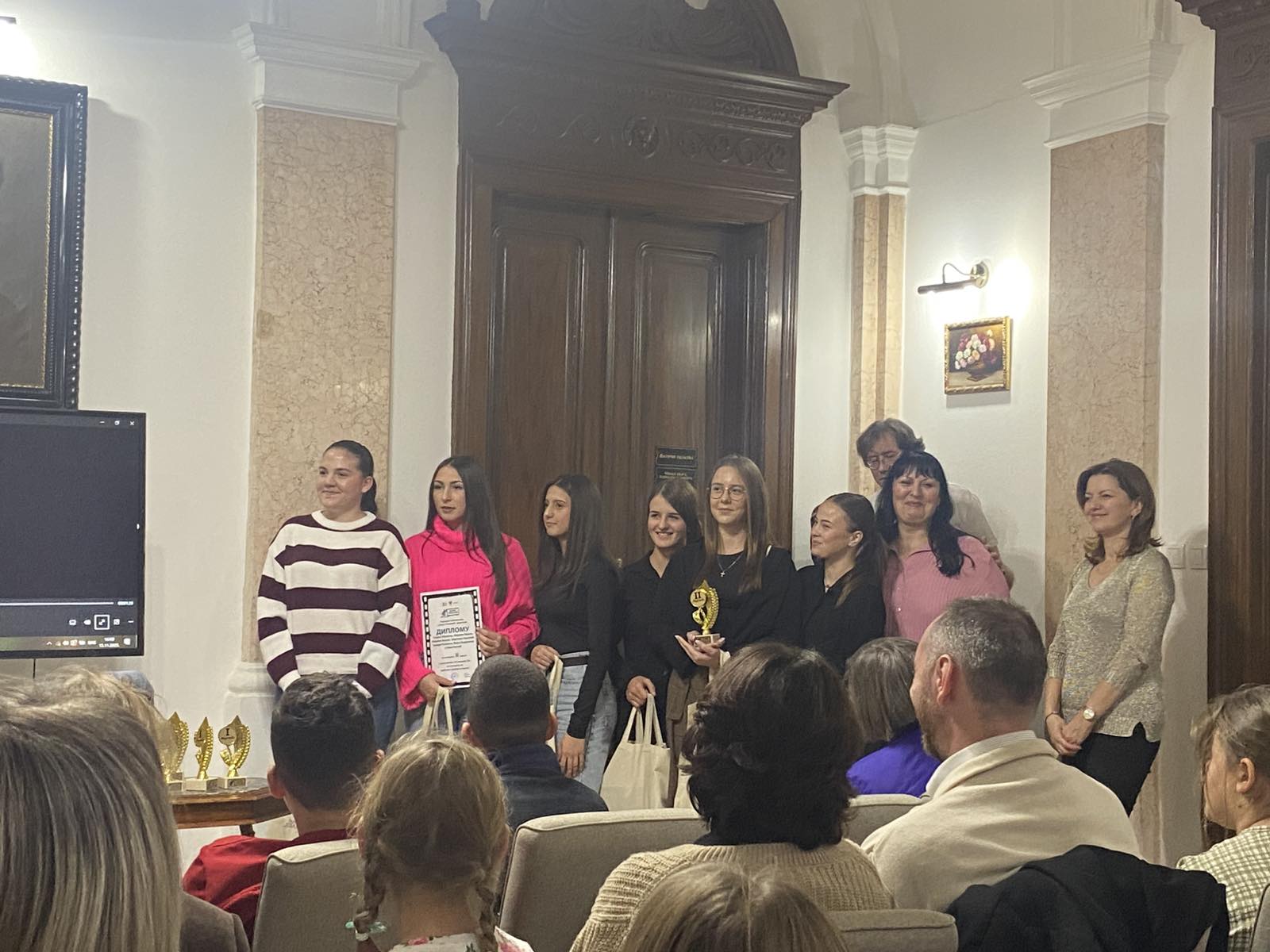 A group of people standing in a room

AI-generated content may be incorrect.