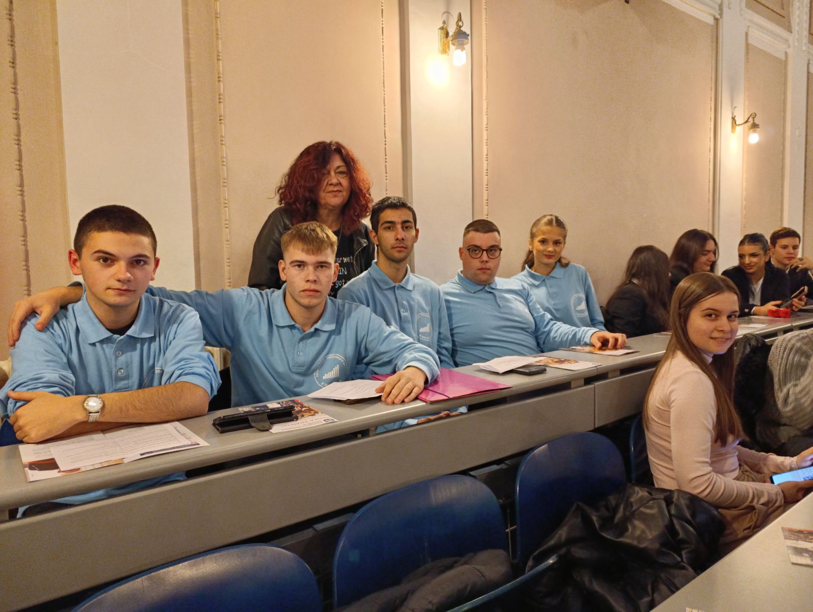 A group of people sitting at a desk
AI-generated content may be incorrect.