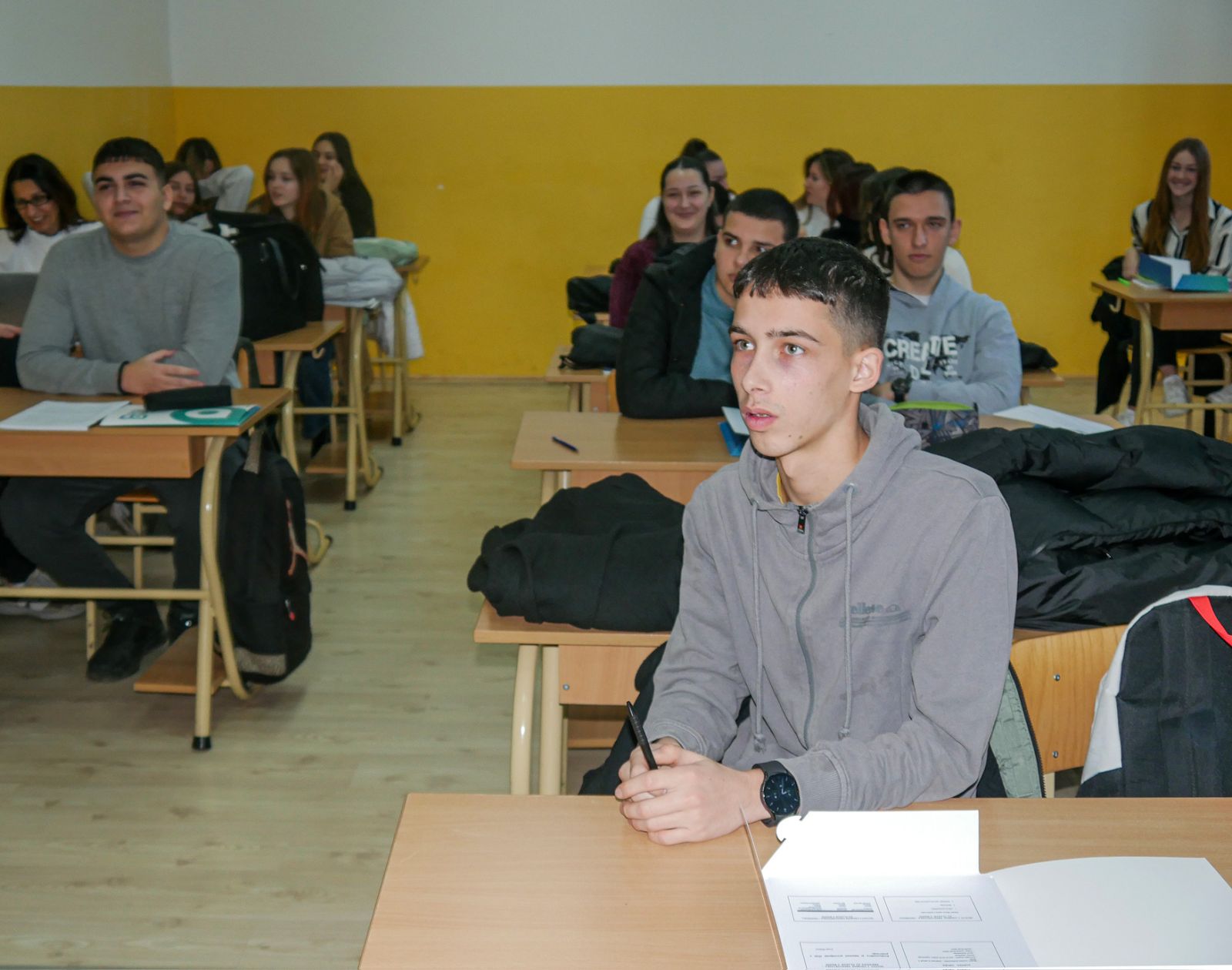 A group of people sitting in a classroom

AI-generated content may be incorrect.