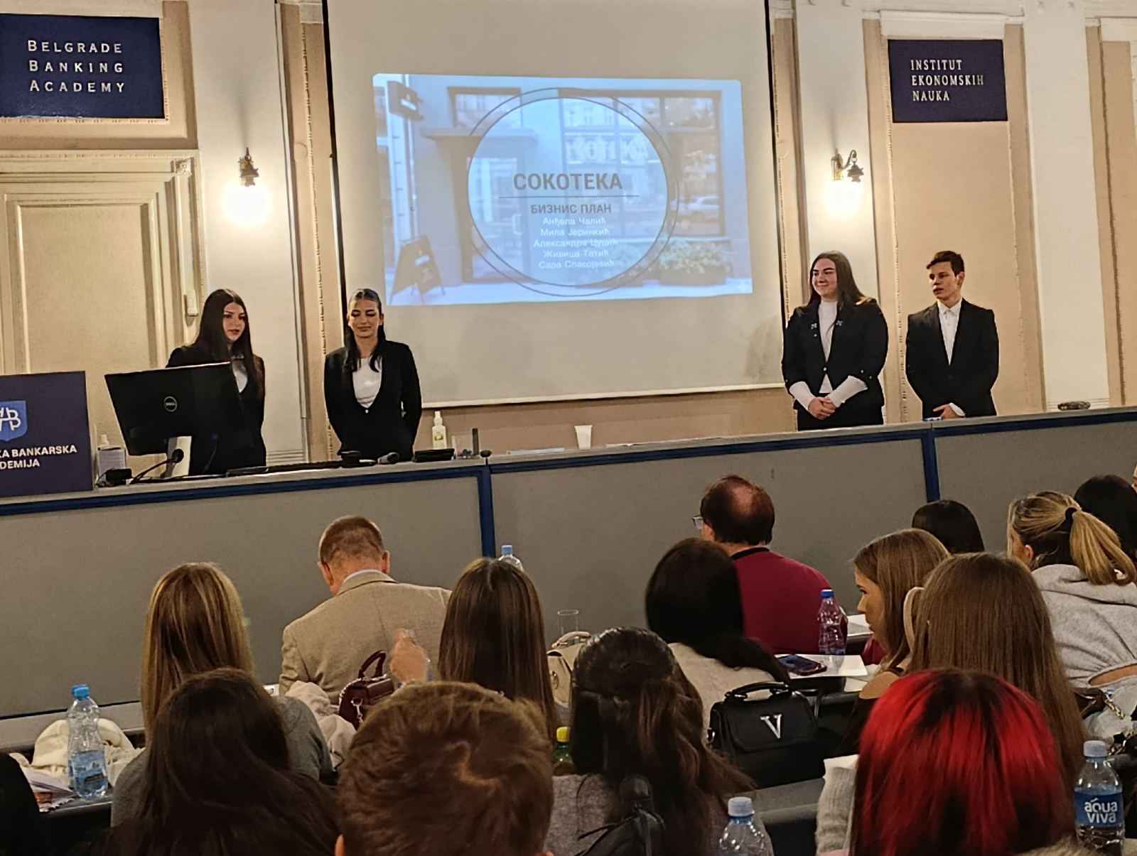 A group of people standing in front of a screen
AI-generated content may be incorrect.