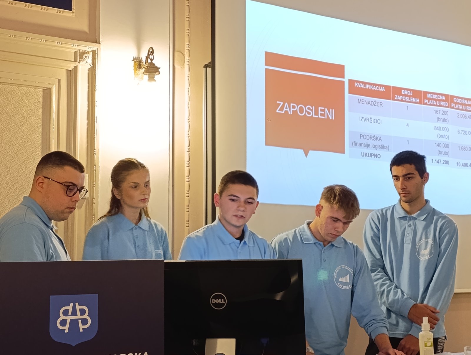 A group of people standing in front of a screen
AI-generated content may be incorrect.