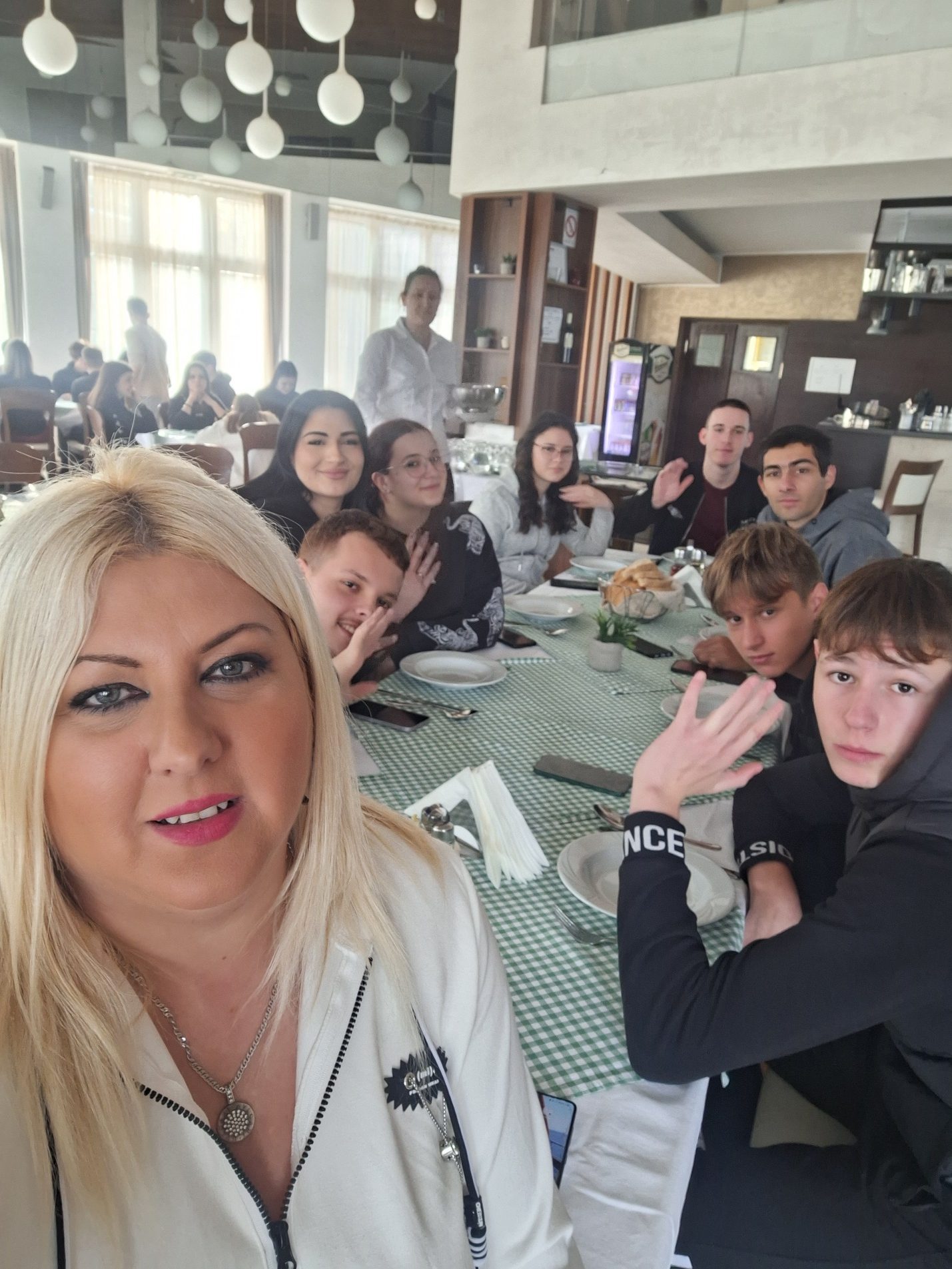 A person smiling at a table with people around it
AI-generated content may be incorrect.